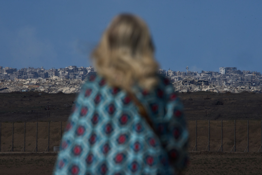 A woman looks at buildings destroyed during Israeli ground and air operations, in the northern Gaza Strip, as seen from southern Israel, Tuesday, Oct. 7, 2025. (AP Photo/Ariel Schalit)