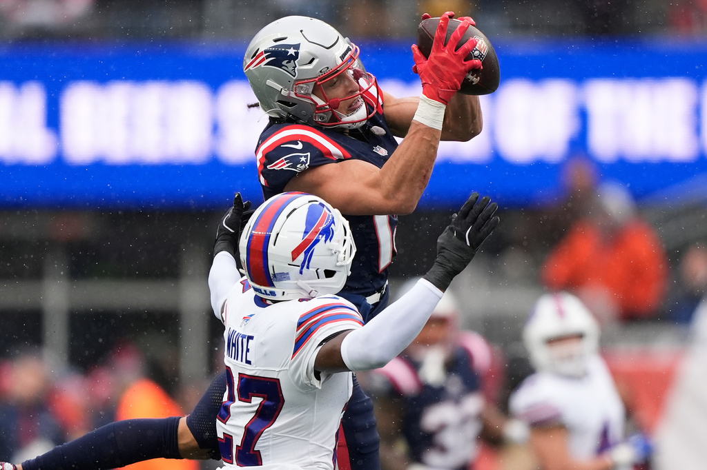 New England Patriots wide receiver Mack Hollins, top, catches a pass over Buffalo Bills cornerback Tre'Davious White (27) during the first half of an NFL football game in Foxborough, Mass., Sunday, Dec. 14, 2025. (AP Photo/Robert F. Bukaty)