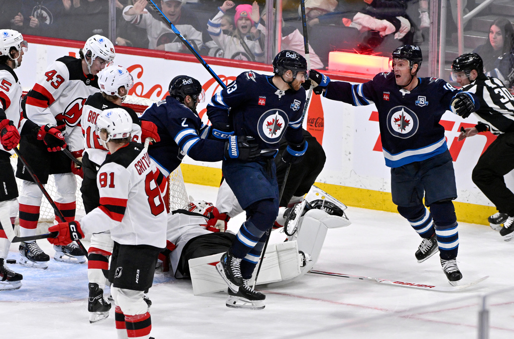Winnipeg Jets' Gabriel Vilardi (13) celebrates after his goal against the New Jersey Devils with Jonathan Toews (19) and Dylan DeMelo (2) during second-period NHL hockey game action in Winnipeg, Manitoba, Sunday, Jan. 11, 2026. (Fred Greenslade/The Canadian Press via AP)