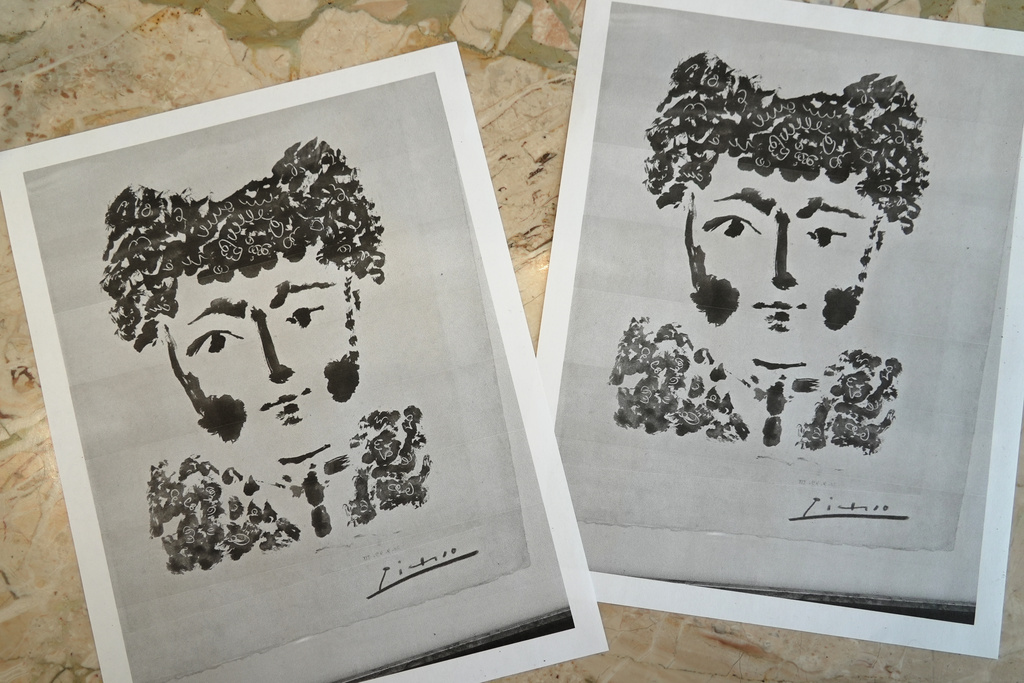 Printouts of a photo of the Pablo Picasso etching, "Torero" are displayed on a table in DeLind Fine Art Appraisals in Milwaukee on Aug. 14, 2026. (AP Photo/Laura Bargfeld)