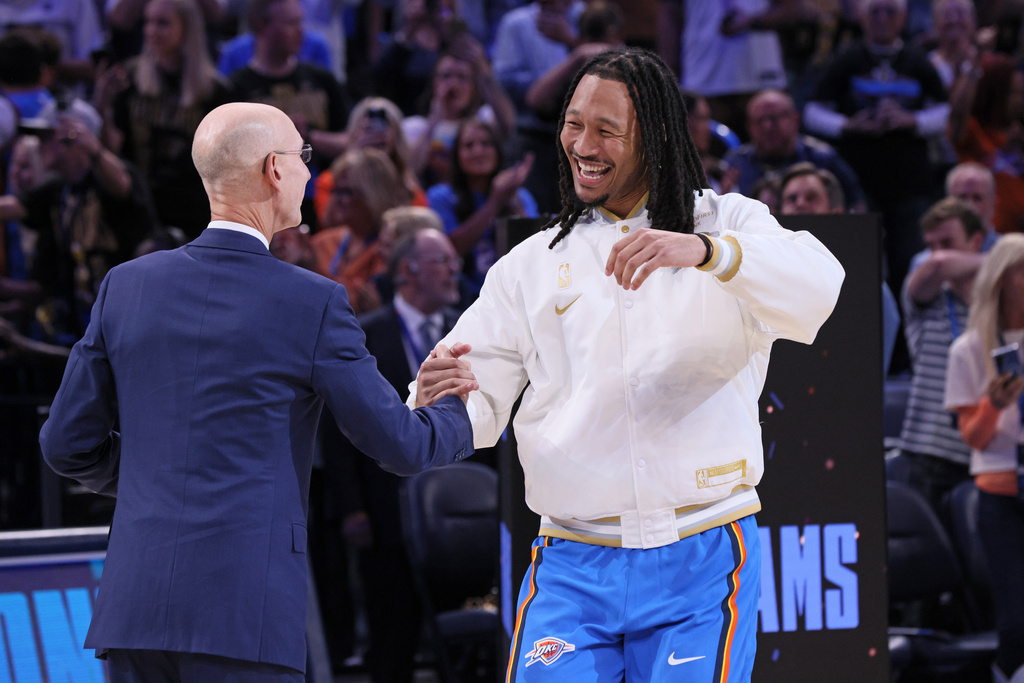 Oklahoma City Thunder forward Jaylin Williams, right, greets NBA commissioner Adam Silver during the championship ring ceremony before an NBA basketball game against the Houston Rockets, Tuesday, Oct. 21, 2025, in Oklahoma City. (AP Photo/Nate Billings)