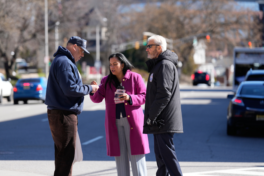 Analilia Mejia, the Democratic candidate running for New Jersey's 11th congressional district, talks to a passerby with Morristown Mayor Tim Dougherty on Tuesday, March 24, 2026, in Morristown, N.J. (AP Photo/Seth Wenig)