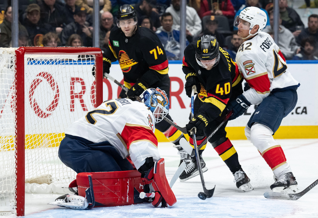 Vancouver Canucks' Elias Pettersson (40) is stopped by Florida Panthers goaltender Sergei Bobrovsky (72) as Gustav Forsling (42) defends during the third period of an NHL hockey game in Vancouver, on Tuesday, March 17, 2026. (Ethan Cairns/The Canadian Press via AP)