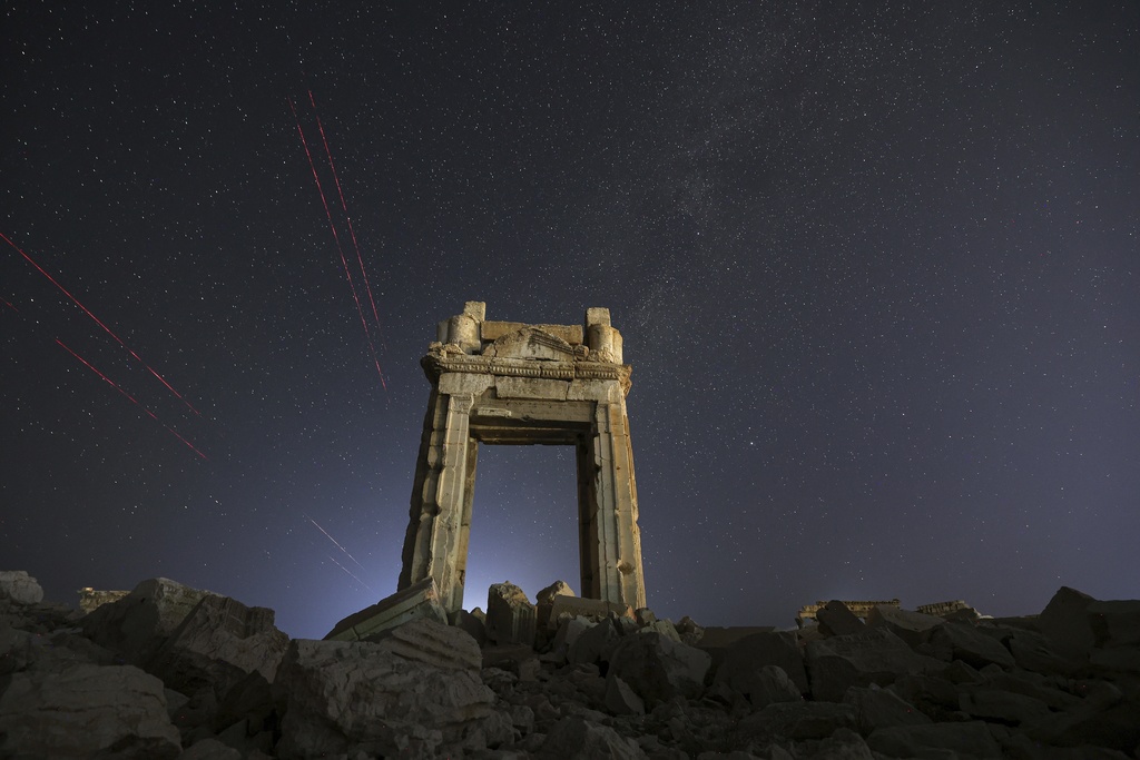 The façade of the Temple of Bel's precinct, in the ruins of the ancient city of Palmyra, is seen under a star-studded sky in Syria, early Wednesday, Aug. 27, 2025. (AP Photo/Ghaith Alsayed)