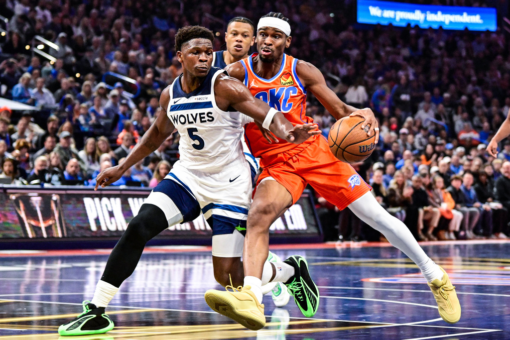 Oklahoma City Thunder guard Shai Gilgeous-Alexander (2) drives against Minnesota Timberwolves guard Anthony Edwards (5) during the first half of an Emirates NBA Cup basketball game, Wednesday, Nov. 26, 2025, in Oklahoma City. (AP Photo/Gerald Leong)