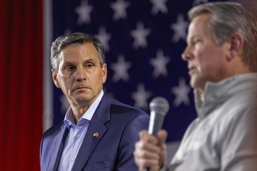 Derek Dooley, left, a Republican candidate for Senate in Georgia, listens as Georgia Gov. Brian Kemp speaks during an Atlanta Young Republicans campaign event Thursday, Feb. 12, 2026, in Atlanta. (AP Photo/Alyssa Pointer)