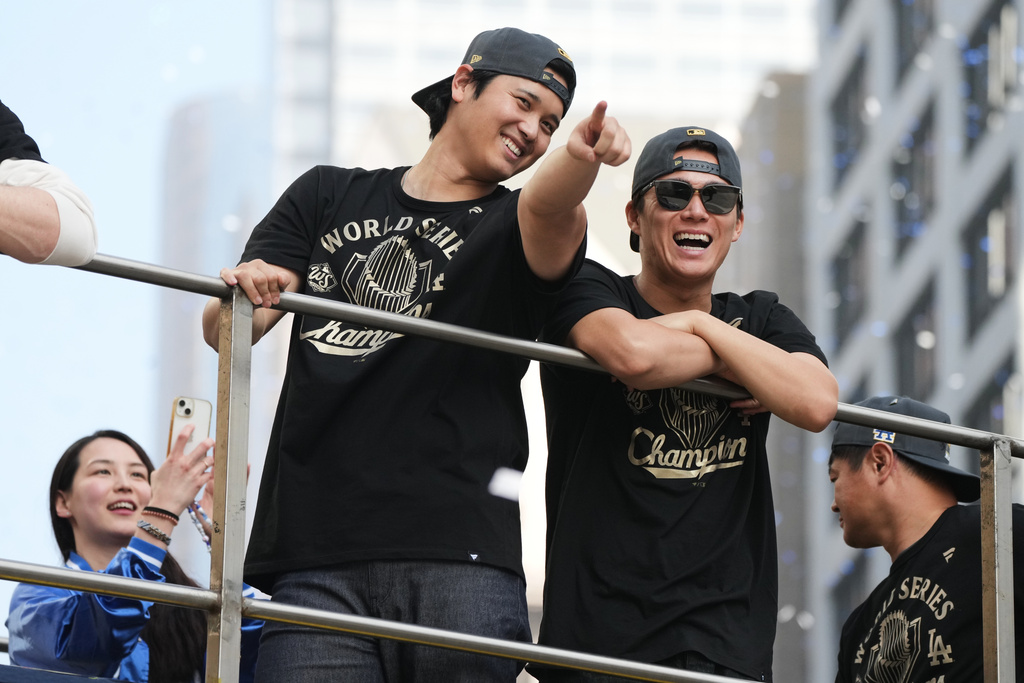 Los Angels Dodgers' Shohei Ohtani, left, and Yoshinobu Yamamoto ride on a double-decker bus during a parade to celebrate the baseball team's World Series win on Monday, Nov. 3, 2025, in Los Angeles. (AP Photo/Jae C. Hong)