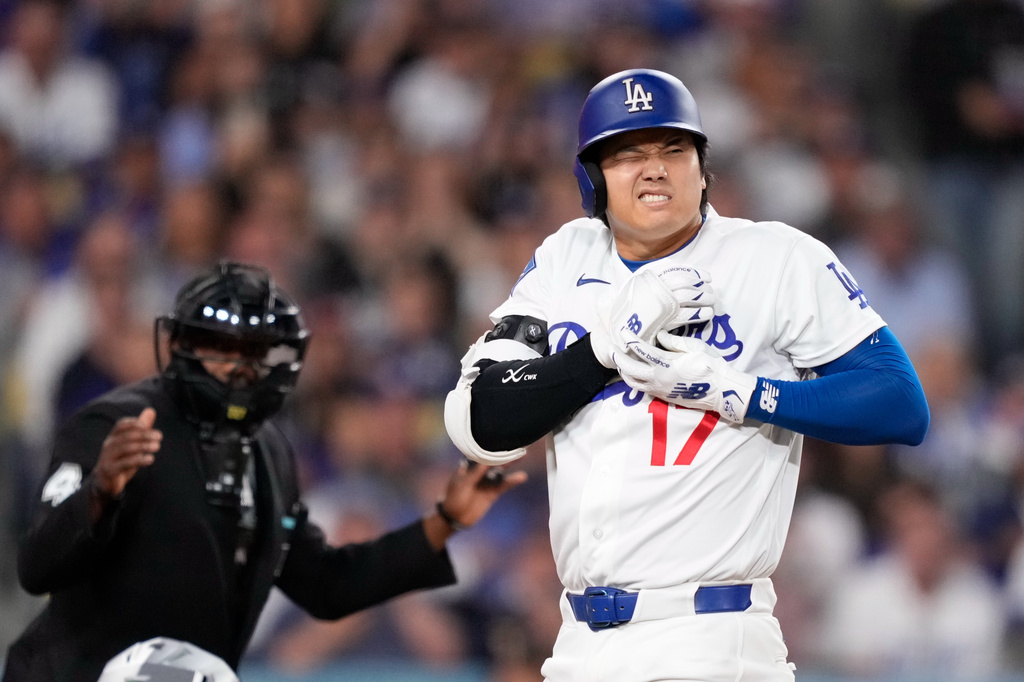 Los Angeles Dodgers' Shohei Ohtani reacts after being hit by a pitch as home plate umpire Malachi Moore watches during the fourth inning of a baseball game against the Colorado Rockies, Tuesday, May 26, 2026, in Los Angeles. (AP Photo/Mark J. Terrill)