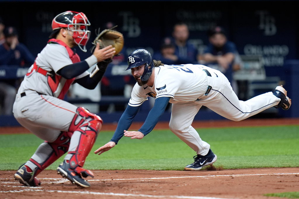 Tampa Bay Rays' Ryan Vilade, right, scores ahead of the throw to Boston Red Sox catcher Mickey Gasper on an RBI single by Cedric Mullins during the fourth inning of a baseball game Tuesday, June 9, 2026, in St. Petersburg, Fla. (AP Photo/Chris O'Meara)