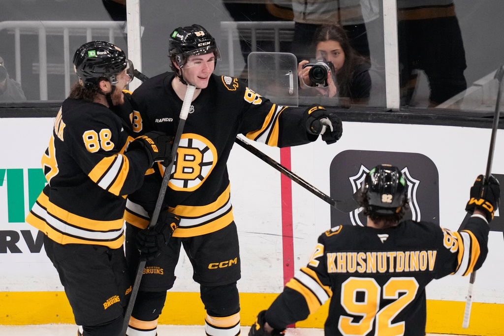 Boston Bruins center Fraser Minten, center, is congratulated after his goal against the Detroit Red Wings during the third period of an NHL hockey game, Tuesday, Jan. 13, 2026, in Boston. (AP Photo/Charles Krupa)