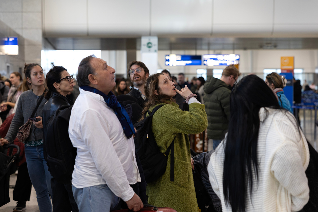 Passengers check a flight information board inside Athens' Eleftherios Venizelos international airport in Athens, Greece, Sunday, Jan. 4, 2026, as many flights were disrupted across Greece. (AP Photo/Yorgos Karahalis)