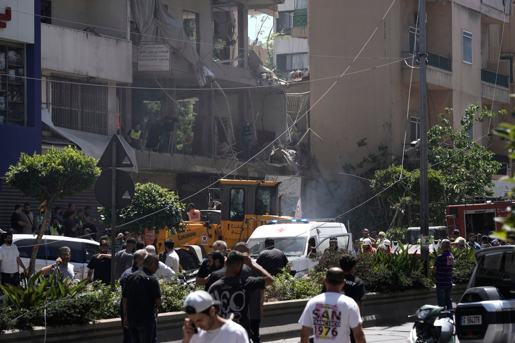 People gather at the site of an Israeli airstrike that struck an apartment in Dahiyeh, Beirut's southern suburbs, Lebanon, Sunday, June 14, 2026. (AP Photo/Bilal Hussein)
