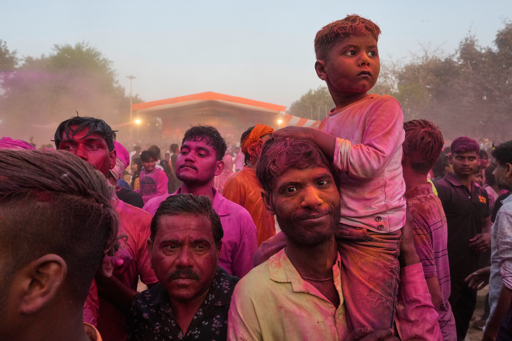 Devotees smeared with colors watch artists perform during Holi festival celebrations at the Shri Krishna Janmabhoomi Temple complex in Mathura, India, on Feb. 27, 2026. (AP Photo/Manish Swarup)
