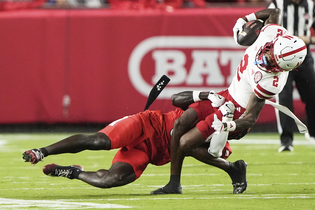Cincinnati defensive back Jiquan Sanks, left, tackles Nebraska wide receiver Jacory Barney, Jr. (2) during the first half of an NCAA college football game Thursday, Aug. 28, 2025, at Arrowhead Stadium in Kansas City, Mo. (AP Photo/Charlie Riedel)