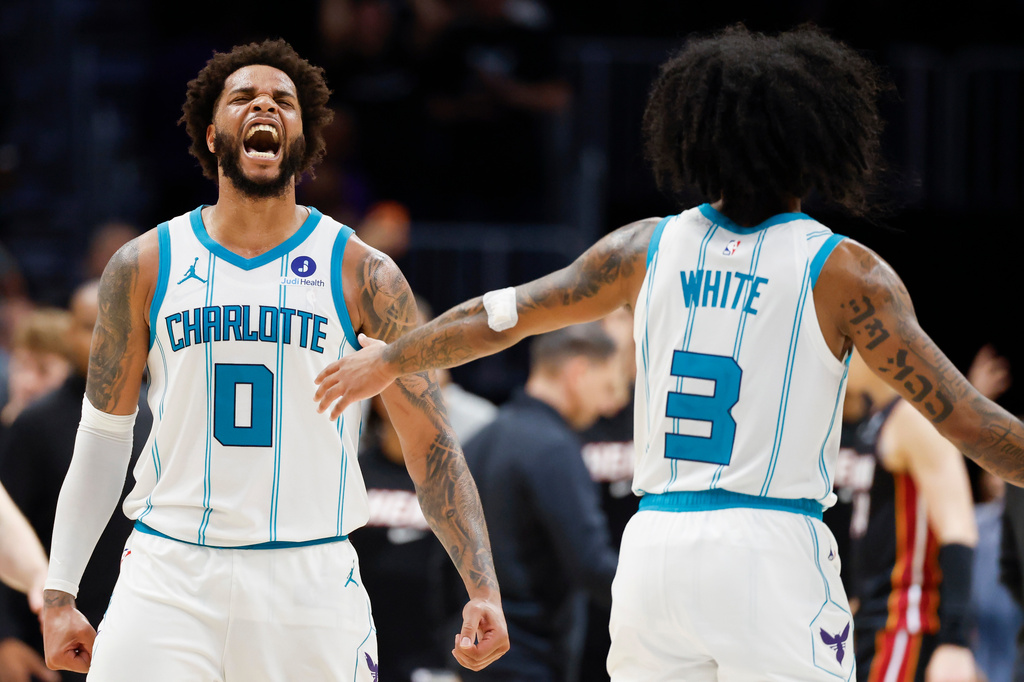 Charlotte Hornets forward Miles Bridges (0) reacts after scoring against the Miami Heat as guard Coby White looks on during the second half of an NBA play-in tournament basketball game in Charlotte, N.C., Tuesday, April 14, 2026. (AP Photo/Nell Redmond)