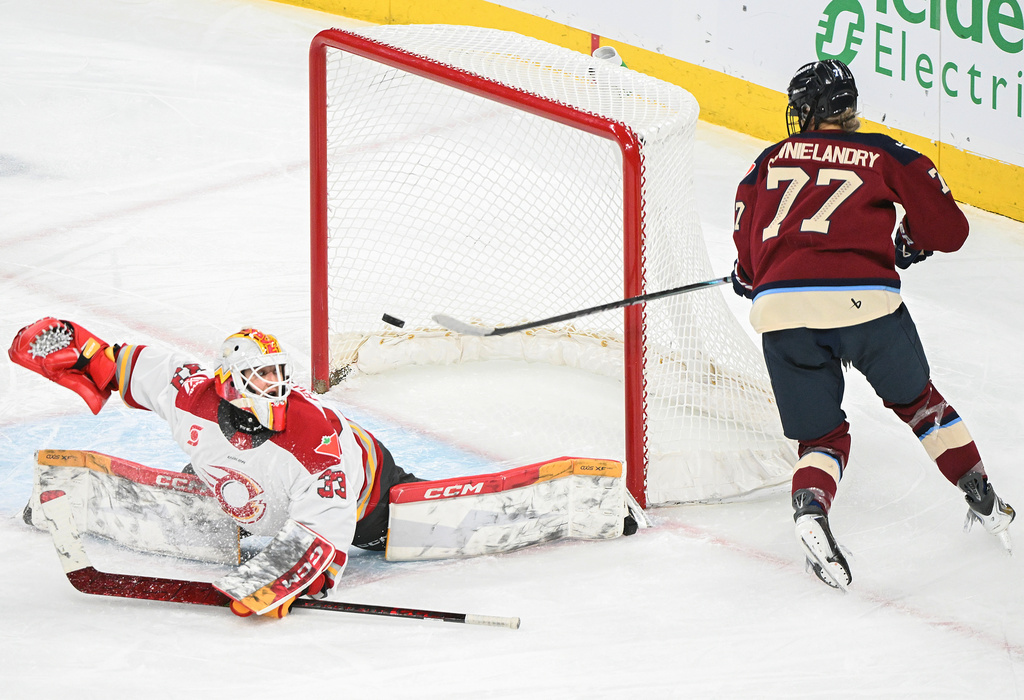 Montreal Victoire's Jade Downie-Landry (77) misses the net as Ottawa Charge goaltender Gwyneth Philips (33) attempts a save during the second period of an PWHL hockey game in Laval, Que., Tuesday, Jan. 13, 2026. (Graham Hughes/The Canadian Press via AP)