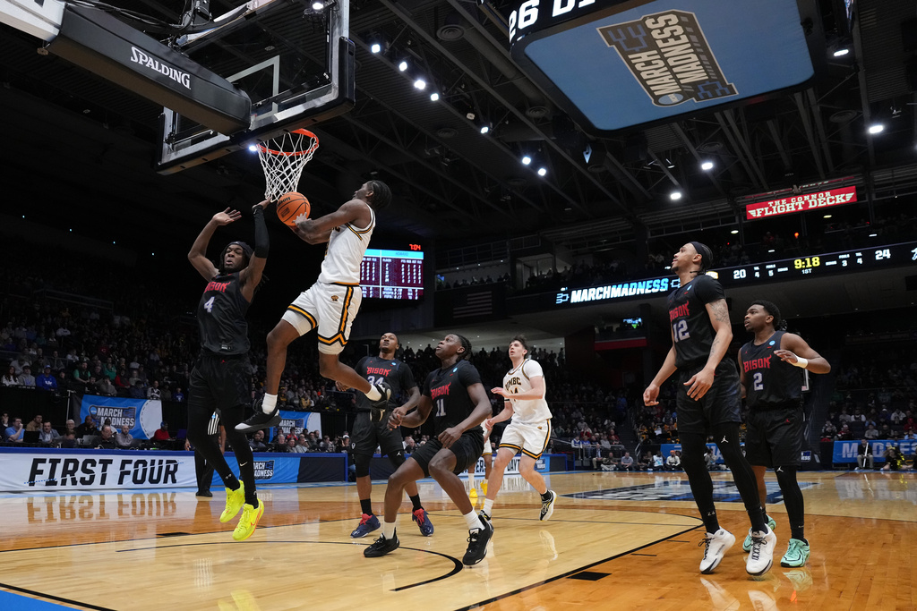 UMBC guard Jah'likai King (4) scores at the basket as Howard guard Alex Cotton (4) defends during the first half in a First Four college basketball game in the NCAA Tournament, Tuesday, March 17, 2026, in Dayton, Ohio. (AP Photo/Kareem Elgazzar)