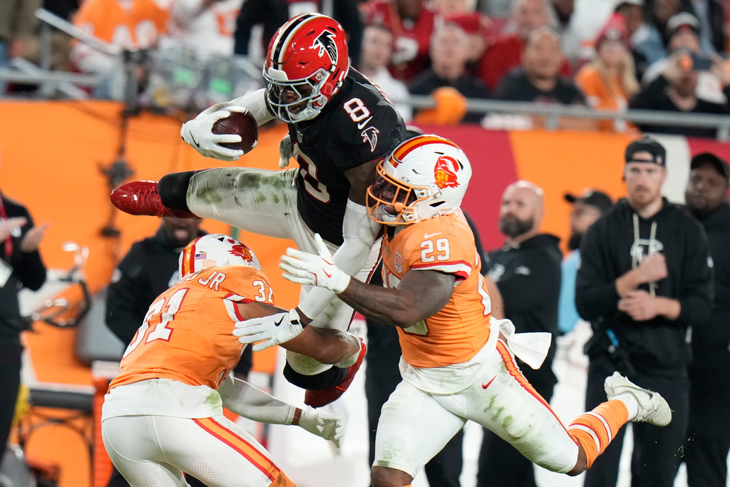 Atlanta Falcons tight end Kyle Pitts Sr. (8) leaps over Tampa Bay Buccaneers safety Christian Izien (29) during the first half of an NFL football game, Thursday, Dec. 11, 2025, in Tampa, Fla. (AP Photo/Chris O'Meara)