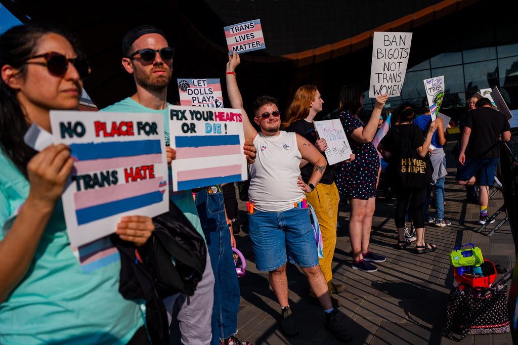 Demonstrators rally in support of transgender athletes in women's sports outside of Barclay's Center before the WNBA basketball game between the Indiana Fever and the New York Liberty, Saturday, Aug. 22, 2026, in New York. (AP Photo/Angelina Katsanis)