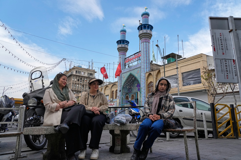 FILE - Women sit in front of a mosque around the traditional grand bazaar of Tehran, Iran, March 29, 2026. (AP Photo/Vahid Salemi, File)