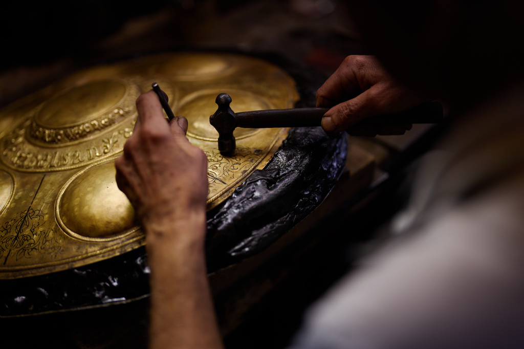 Master inlay and relief craftsman Halit Cakar works on a metal piece in his workshop in Istanbul's Eminonu commercial district, Thursday, Aug. 6, 2026. (AP Photo/Francisco Seco)