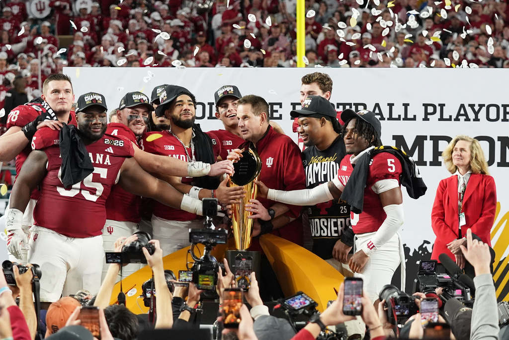FILE - Indiana head coach Curt Cignetti, third from right, stands with players and the trophy after Indiana defeated Miami in a College Football Playoff national championship game, Jan. 19, 2026, in Miami Gardens, Fla. (AP Photo/Lynne Sladky, file)