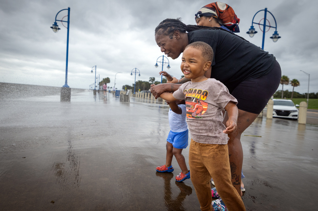 Michael Ray, 3, holds the hands of his grandmother, Shirella Ray, as they and other family members watch waves from Lake Pontchartrain crash along Lakeshore Drive in New Orleans as Tropical Storm Bertha approaches the Louisiana coast on Wednesday, July 22, 2026. (Brett Duke/The Advocate via AP)