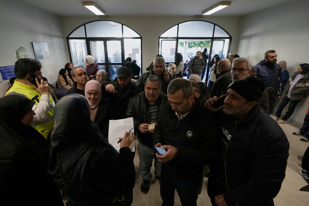 Displaced families fleeing Israeli airstrikes in southern Lebanon register their names as they arrive at a school turned into a shelter, in Beirut, Lebanon, Monday, March 2, 2026. (AP Photo/Bilal Hussein)