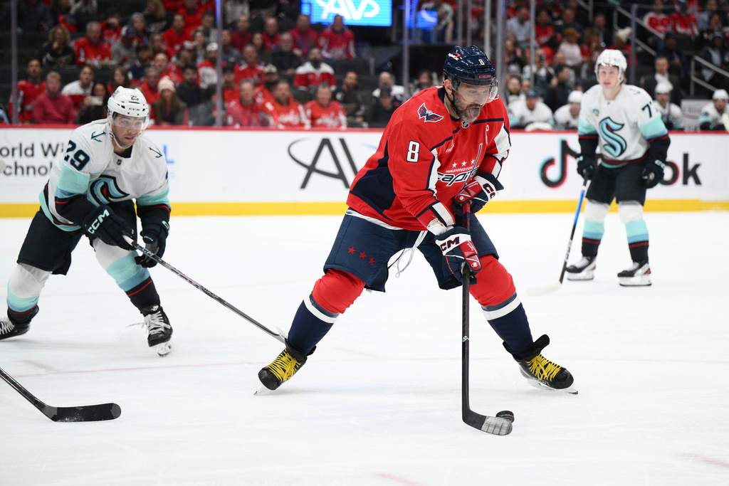 Washington Capitals left wing Alex Ovechkin (8) skates with the puck past Seattle Kraken defenseman Vince Dunn (29) during the first period of an NHL hockey game, Tuesday, Oct. 21, 2025, in Washington. (AP Photo/Nick Wass)