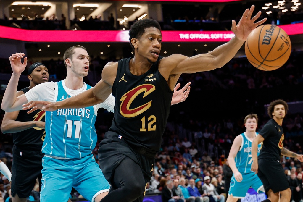 Cleveland Cavaliers forward De'andre Hunter (12) grabs a loose ball ahead of Charlotte Hornets center Ryan Kalkbrenner during the first half of an NBA basketball game in Charlotte, N.C., Wednesday, Jan. 21, 2026. (AP Photo/Nell Redmond)