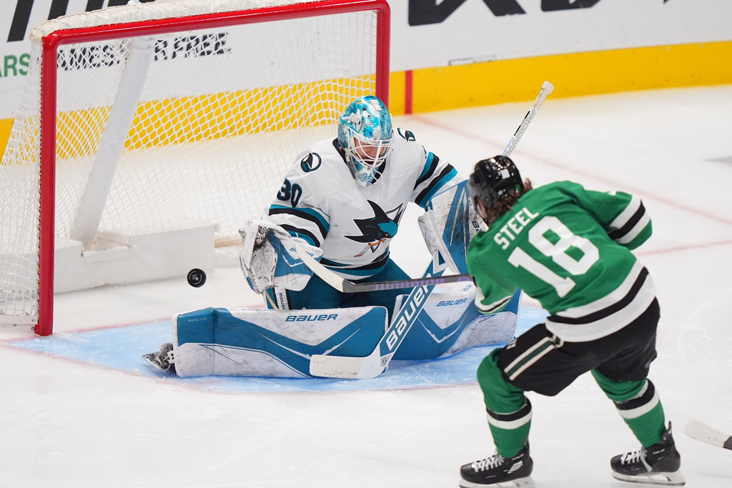 San Jose Sharks goaltender Yaroslav Askarov (30) defends against Dallas Stars center Sam Steel (18) during the third period of an NHL hockey game Friday, Dec. 5, 2025, in Dallas. (AP Photo/LM Otero)
