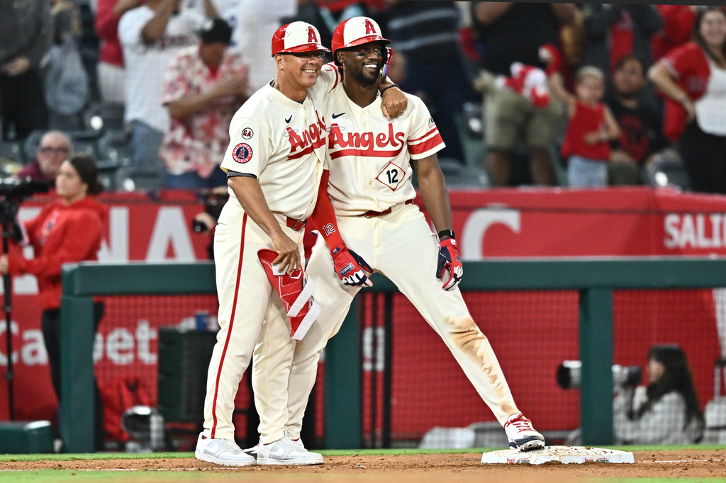 Los Angeles Angels' Jorge Soler, right, is greeted by third base coach Keith Johnson after hitting an RBI triple during the eighth inning of a baseball game against the Colorado Rockies, Monday, June 1, 2026, in Anaheim, Calif. (AP Photo/William Liang)