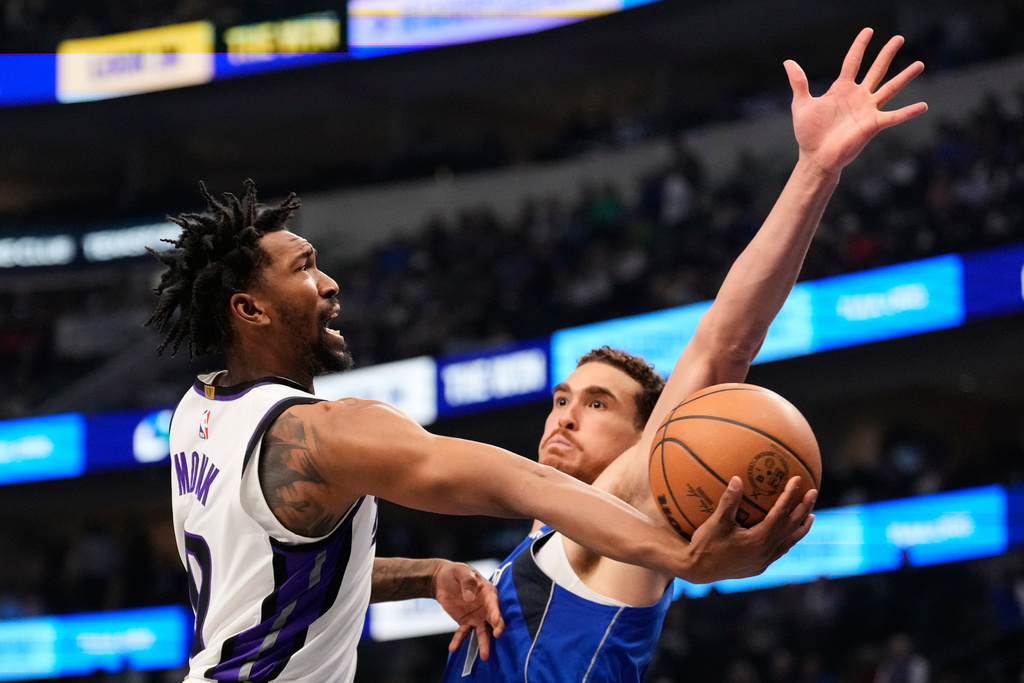 Sacramento Kings guard Malik Monk shoots at Dallas Mavericks' Dwight Powell, right, defends in the first half of an NBA basketball game in Dallas, Thursday, Feb. 26, 2026. (AP Photo/Tony Gutierrez)