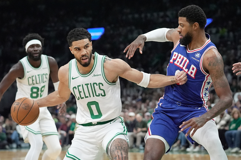 Boston Celtics forward Jayson Tatum (0) drives against Philadelphia 76ers forward Paul George, right, during the first half in Game 1 of a first-round NBA playoffs basketball game, Sunday, April 19, 2026, in Boston. (AP Photo/Robert F. Bukaty)