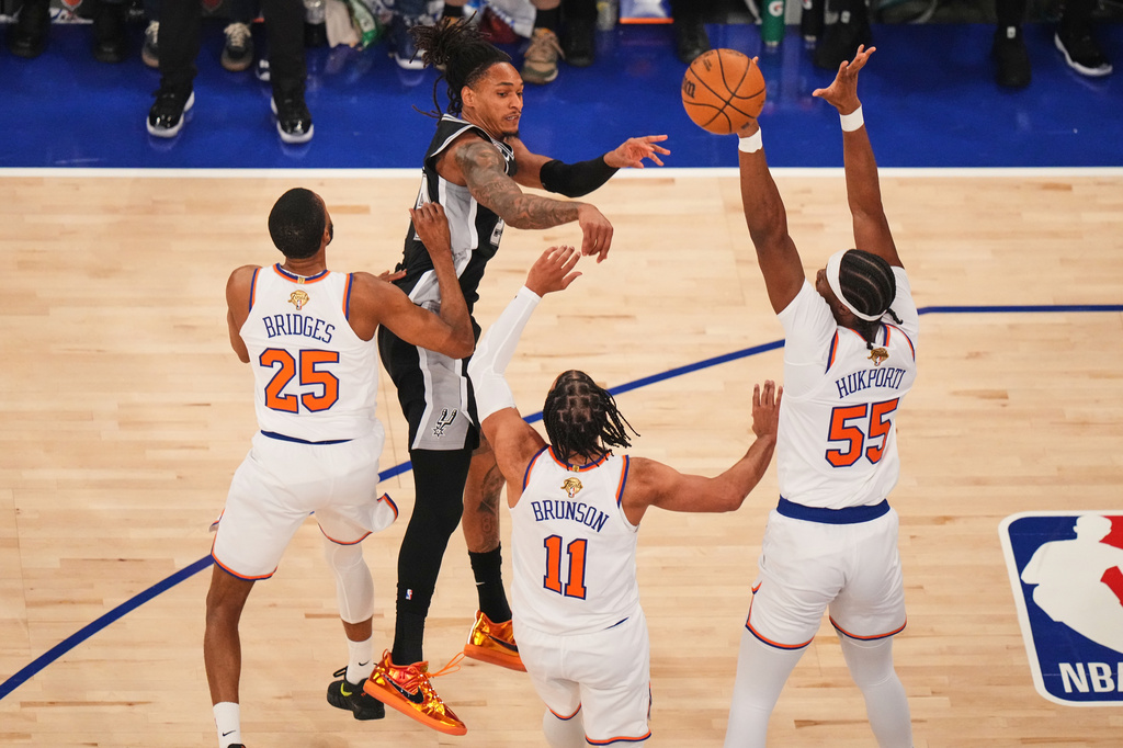 San Antonio Spurs guard Devin Vassell passes the ball as New York Knicks guard Mikal Bridges (25), guard Jalen Brunson (11) and center Ariel Hukporti (55) defend during the first half of Game 4 of the NBA Finals basketball series, Wednesday, June 10, 2026, in New York. (AP Photo/Frank Franklin II)