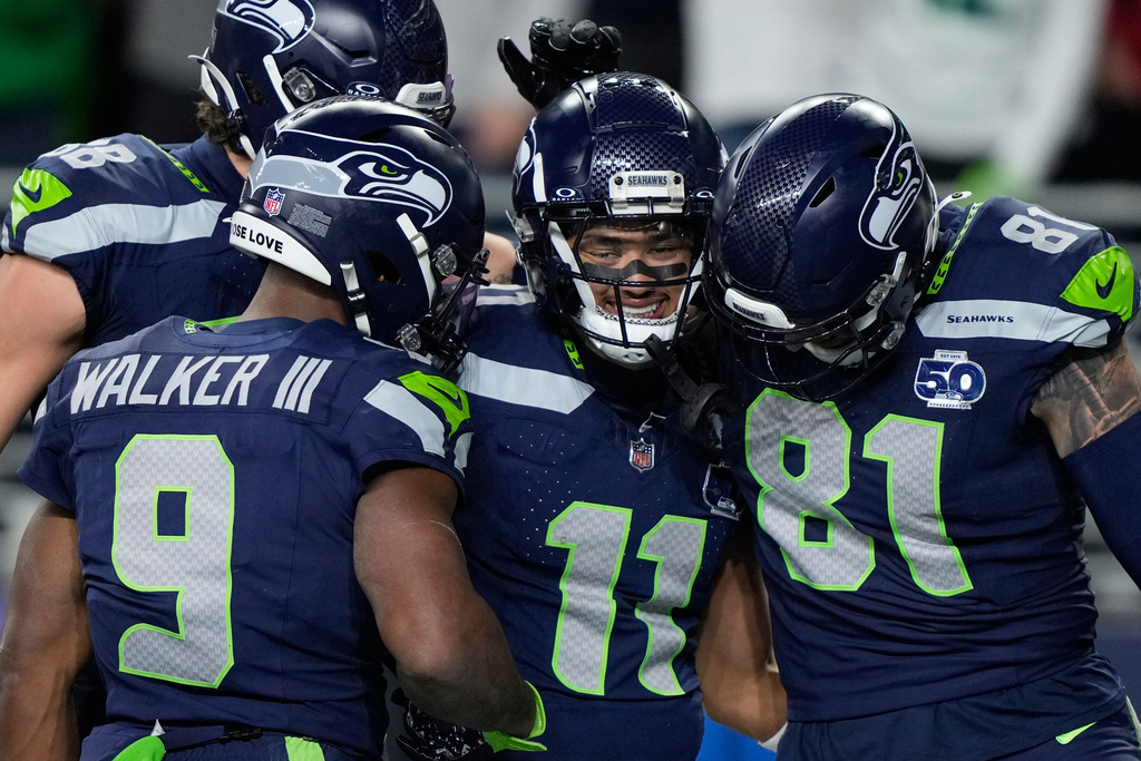 Seattle Seahawks wide receiver Jaxon Smith-Njigba (11) celebrates with teammates after scoring a touchdown during the first half of an NFL football divisional playoff game against the San Francisco 49ers, Saturday, Jan. 17, 2026, in Seattle. (AP Photo/Stephen Brashear)