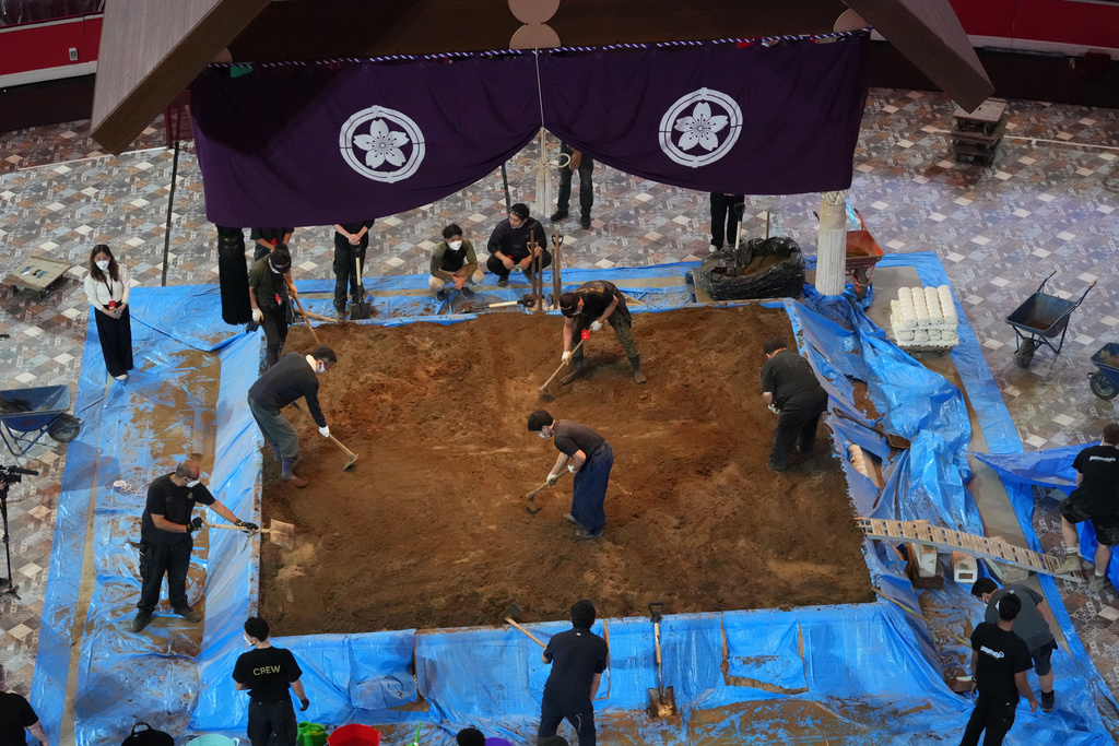 Workers build up the dohyo, the sacred sumo wrestling ring and the ceremonial heart of the event, during a ritualized process that combines centuries-old tradition with precise engineering at the Royal Albert Hall in London, Monday, Oct. 13, 2025 ahead of The Grand Sumo Tournament. (AP Photo/Frank Augstein)