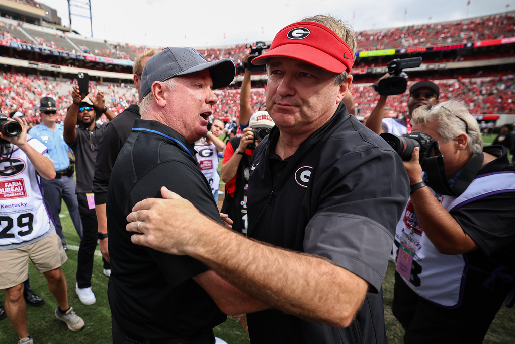 Kentucky head coach Mark Stoops, left, and Georgia head coach Kirby Smart, right, meet at midfield after an NCAA college football game, Saturday, Oct. 4, 2025, in Athens, Ga. (AP Photo/Colin Hubbard)