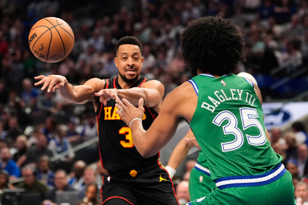 Atlanta Hawks guard CJ McCollum (3) makes a pass around Dallas Mavericks forward Marvin Bagley III (35) in the first half of a NBA basketball game in Dallas, Wednesday, March 18, 2026. (AP Photo/Tony Gutierrez)