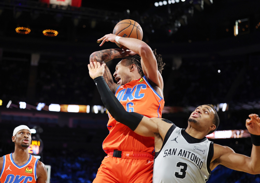 Oklahoma City Thunder forward Jaylin Williams (6) and San Antonio Spurs forward Keldon Johnson (3) collide while going for a rebound during the second half of an NBA Cup semifinals basketball game, Saturday, Dec. 13, 2025, in Las Vegas. (AP Photo/Ronda Churchill)