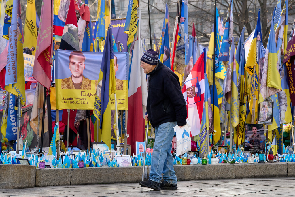 A man walks around an improvised memorial to fallen soldiers killed in the Russia-Ukraine war at Independence square in Kyiv, Ukraine, Wednesday, Dec. 10, 2025. (AP Photo/Efrem Lukatsky)