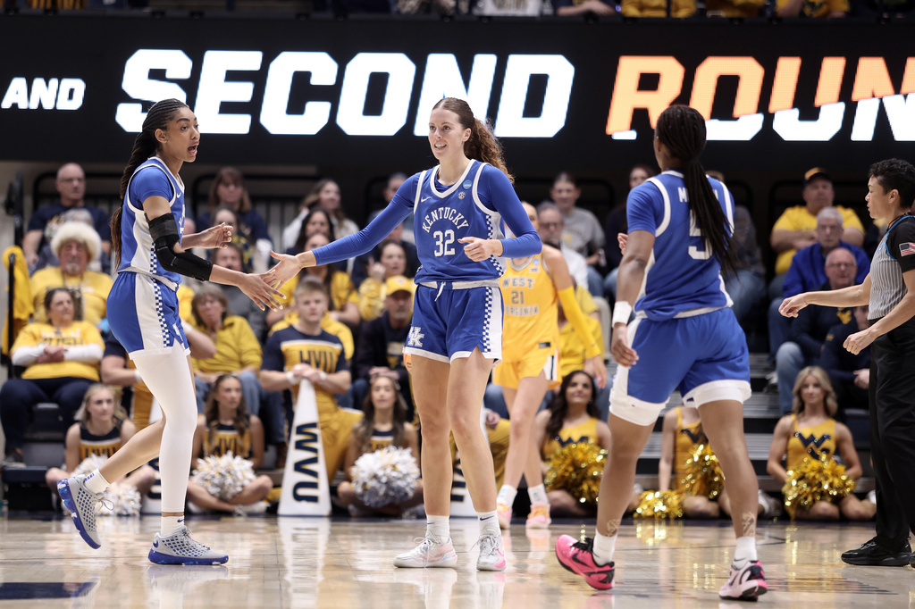 Kentucky forwards Teonni Key, left, Amelia Hassett (32), and guard Tonie Morgan (5) meet on court in the first half in the second round of the NCAA college basketball tournament against West Virginia, Monday, March 23, 2026, in Morgantown, W.Va. (AP Photo/Kathleen Batten)