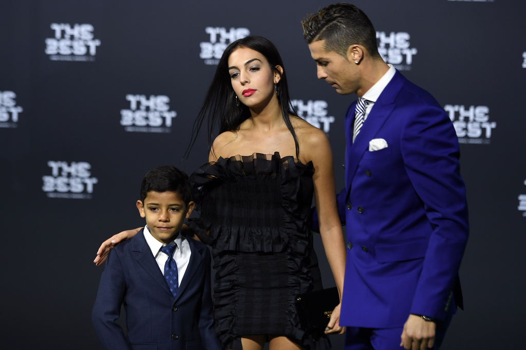 FILE -Portugal's soccer player Cristiano Ronaldo, right, his girlfriend Georgina Rodriguez, center, and his son Ronaldo jr., left, arrive on the green carpet prior during the The Best FIFA Football Awards 2016 ceremony held at the Swiss TV studio in Zurich, Switzerland, Jan. 9, 2017. (Walter Bieri/Keystone via AP, File)