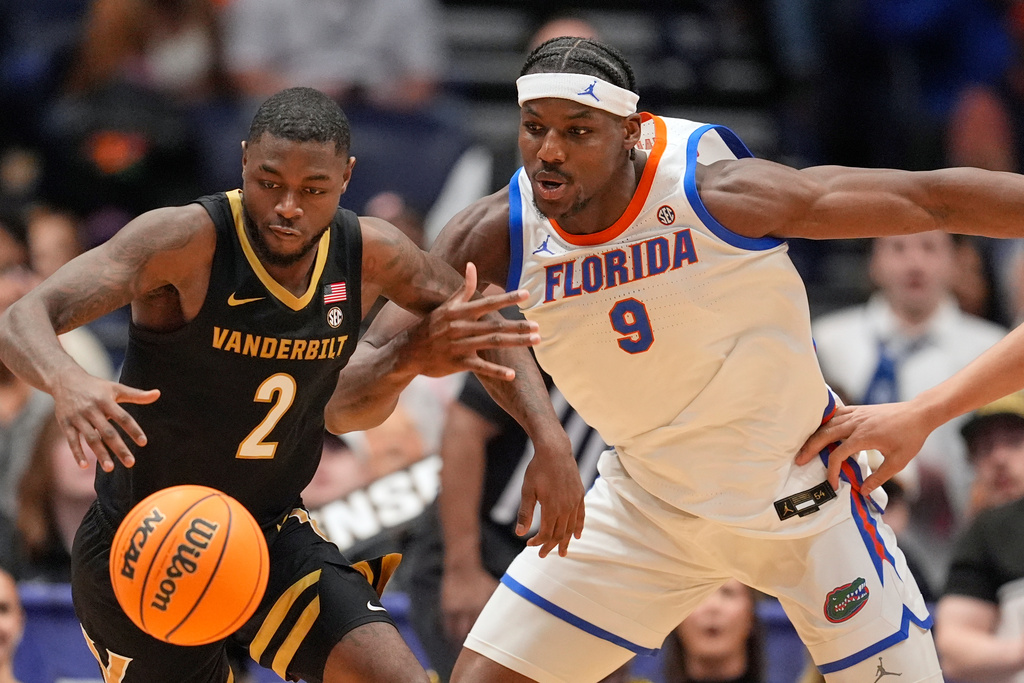 Vanderbilt guard Duke Miles (2) steals the ball from Florida center Rueben Chinyelu (9) during the first half of an NCAA college basketball game in the semifinals of the Southeastern Conference tournament Saturday, March 14, 2026, in Nashville, Tenn. (AP Photo/George Walker IV)