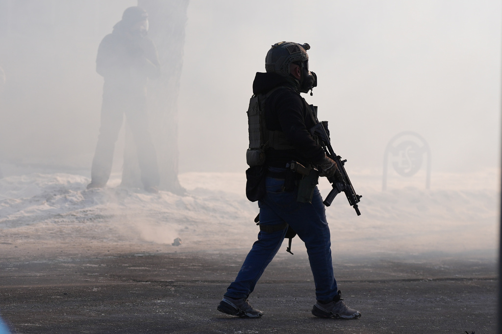 Federal immigration officers deploy tear gas after a shooting Saturday, Jan. 24, 2026, in Minneapolis. (AP Photo/Abbie Parr)