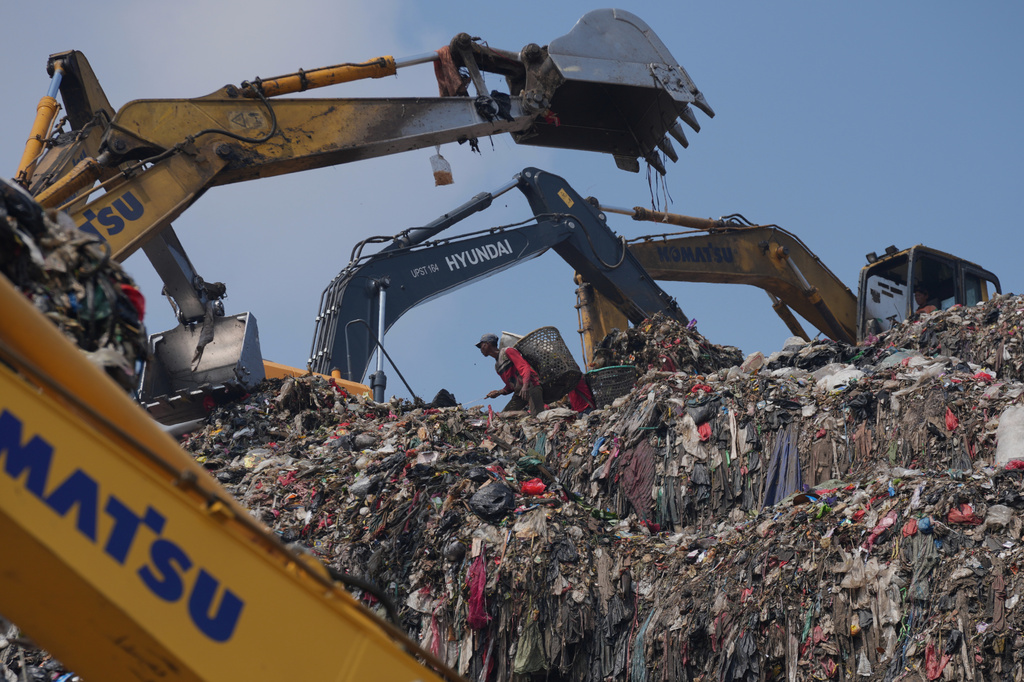 A waste picker looks for recyclable items in a pile of garbage at the Bantargebang landfill on the outskirts of Jakarta, Indonesia, Monday, July 6, 2026. (AP Photo/Tatan Syuflana)