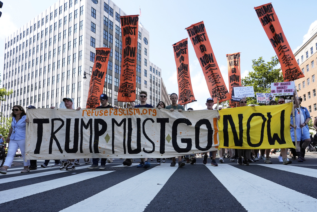 Activists carrying signs march to the White House to protest President Donald Trump's federal takeover of policing of the District of Columbia, Saturday, Aug. 16, 2025, in Washington. (AP Photo/Alex Brandon)