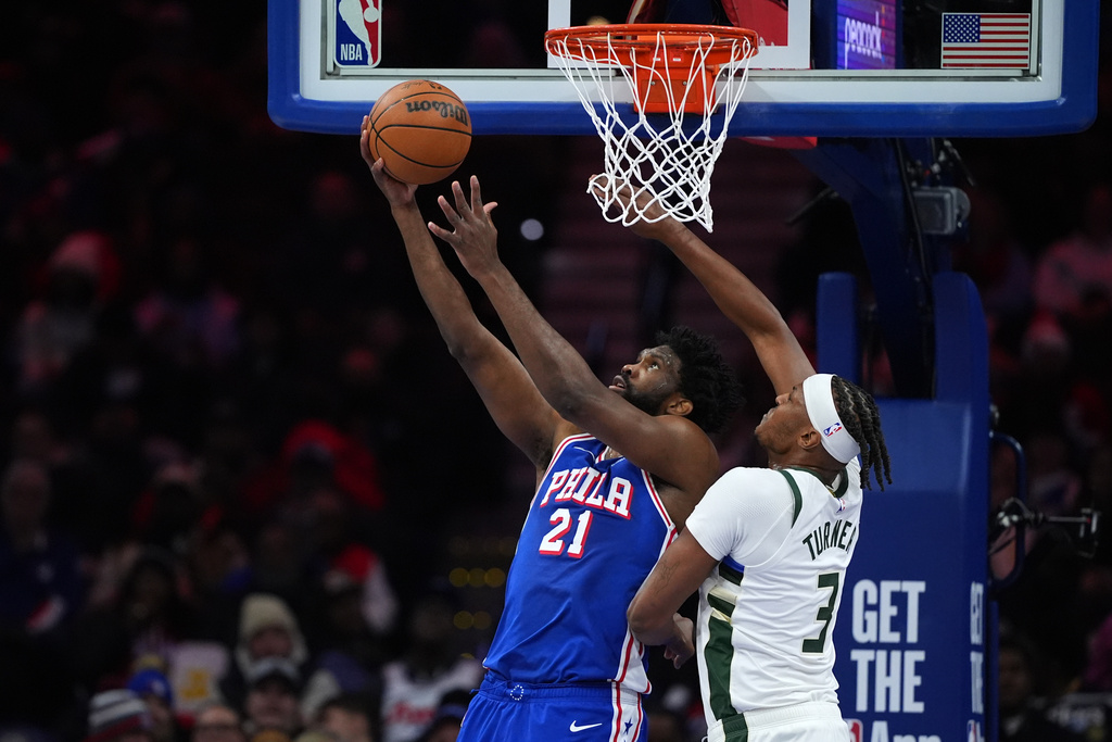 Philadelphia 76ers' Joel Embiid, left, goes up for a shot against Milwaukee Bucks' Myles Turner during the first half of an NBA basketball game Tuesday, Jan. 27, 2026, in Philadelphia. (AP Photo/Matt Slocum)