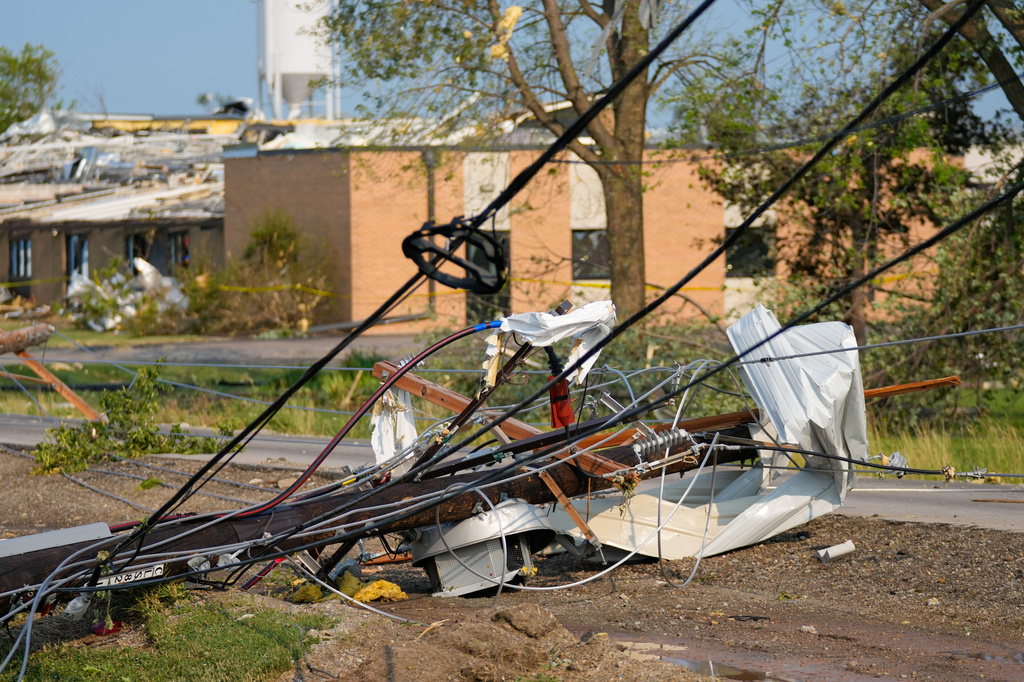 Power lines tangled with debris lie on the ground after a tornado tore through a day before in Appleton., Wis., Tuesday, July 28, 2026. (AP Photo/Kayla Wolf)