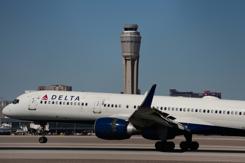 A plane lands at Harry Reid International Airport, Tuesday, Oct. 7, 2025, in Las Vegas. (AP Photo/John Locher)